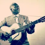 Lead Belly plays guitar