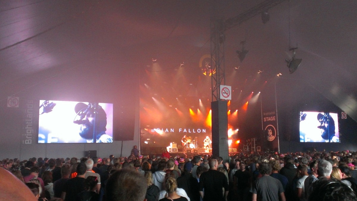 Brian Fallon performing live on stage with a guitar