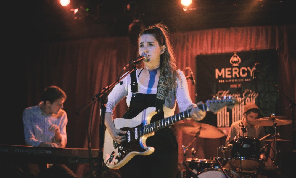Katie Pruitt performing live on stage with guitar