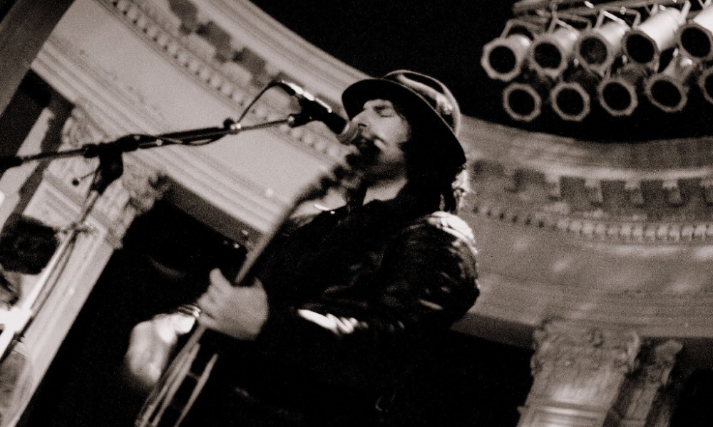Pete Yorn performing live on stage with guitar